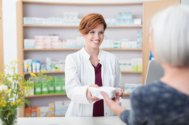 Image of pharmacist handing over a prescription to a patient