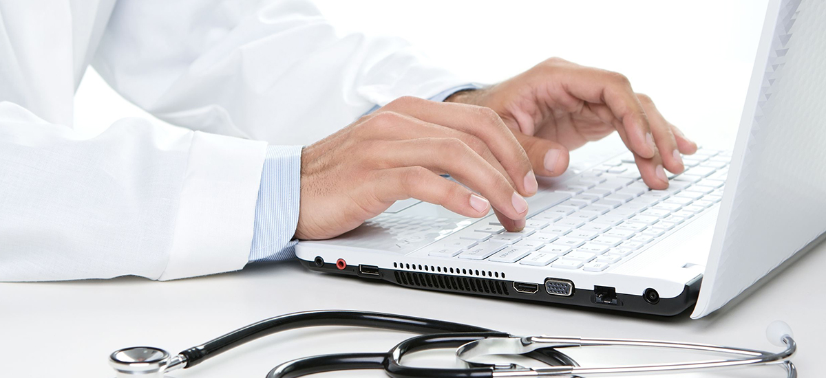 image of doctor typing on laptop keyboard