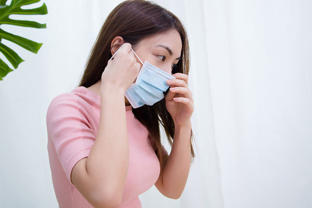 Image of young shielding lady wearing surgical mask . Block is about Sociial and commiunity support during Covid nineteen pandemic