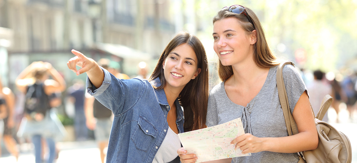 Slide Image of two youg ladies consulting a map with one of the couple pointing a direction